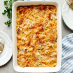 a baked rice a roni chicken casserole in a white pan.