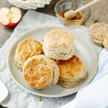 fluffy apple biscuits on a white plate with honey.
