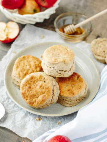 fluffy apple biscuits on a white plate with honey.
