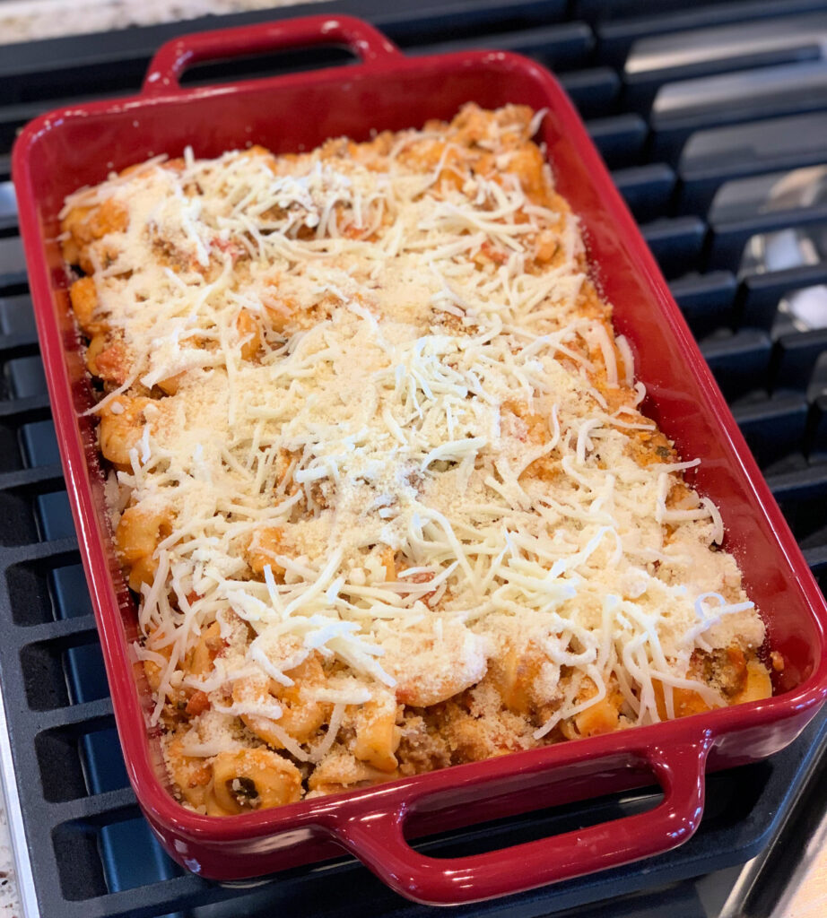 cheesy tortellini with pasta sauce ready to go into the oven