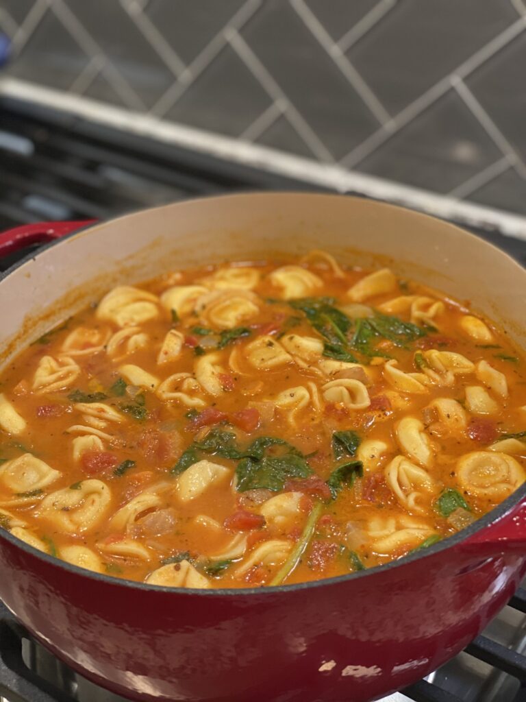 a soup pot full of tomato basil soup simmering on the stove