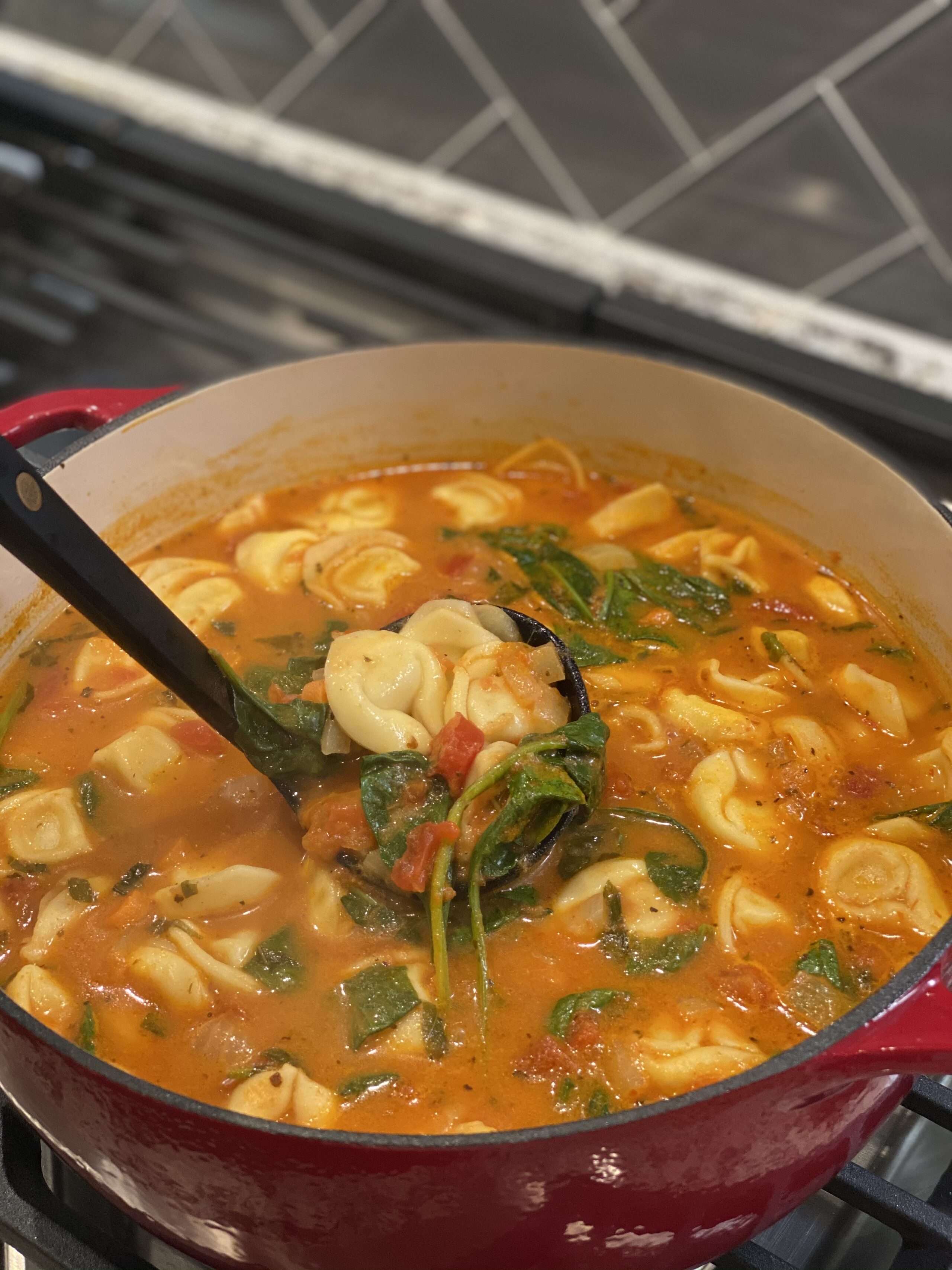 tomato basil tortellini soup in a dutch oven.