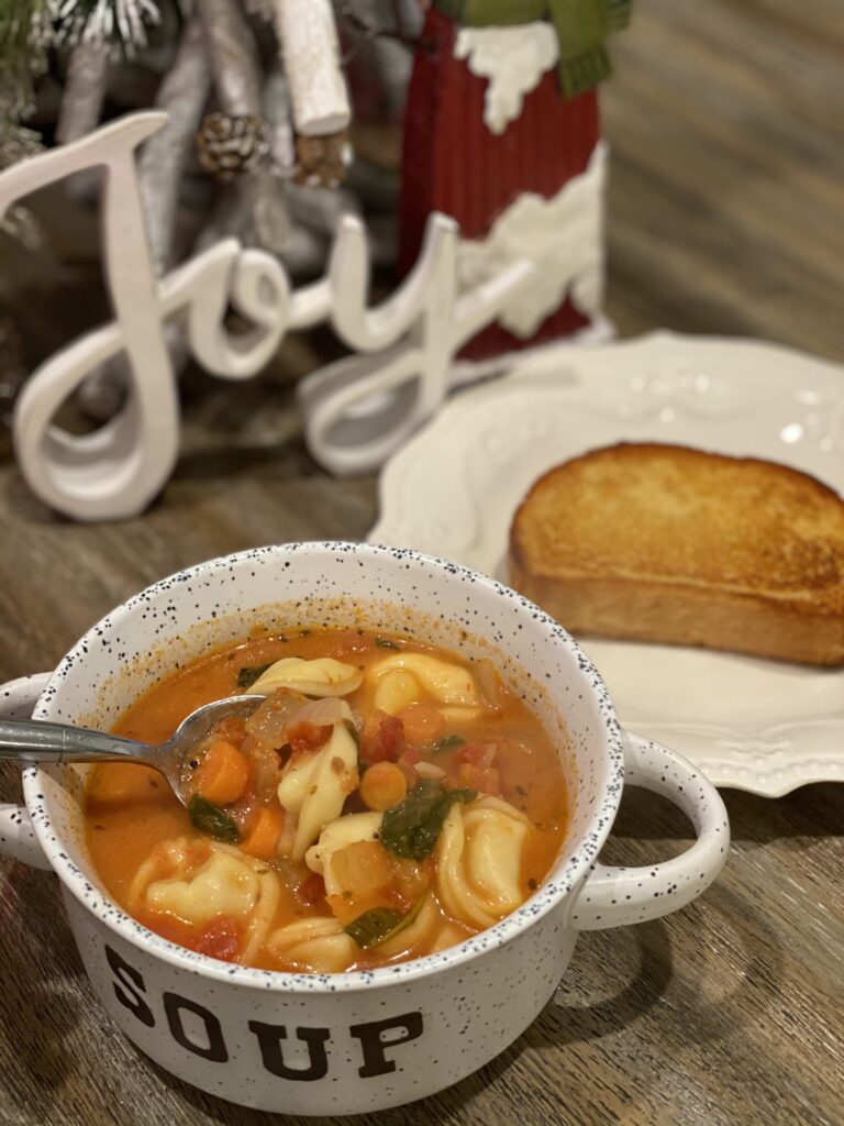 a bowl of tomato basil soup with a side of garlic toast