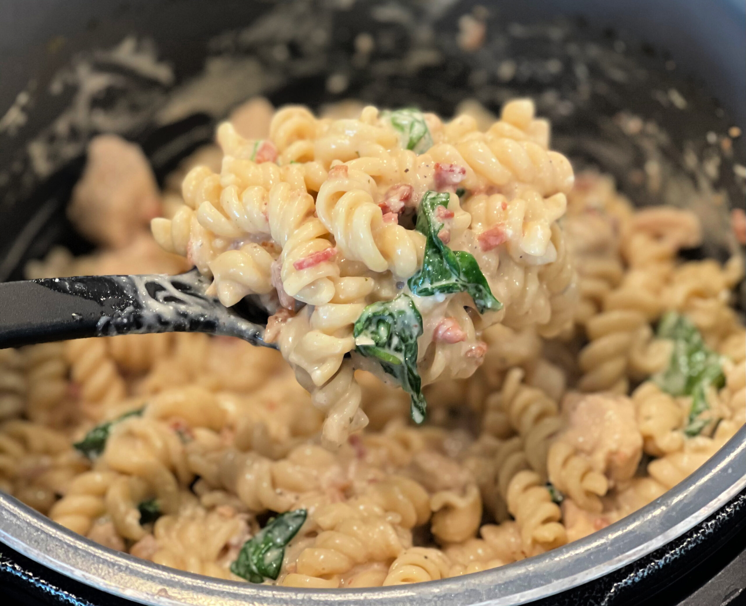 tender pasta with seasoned chicken and spinach in a creamy sauce cooked in the instant pot.
