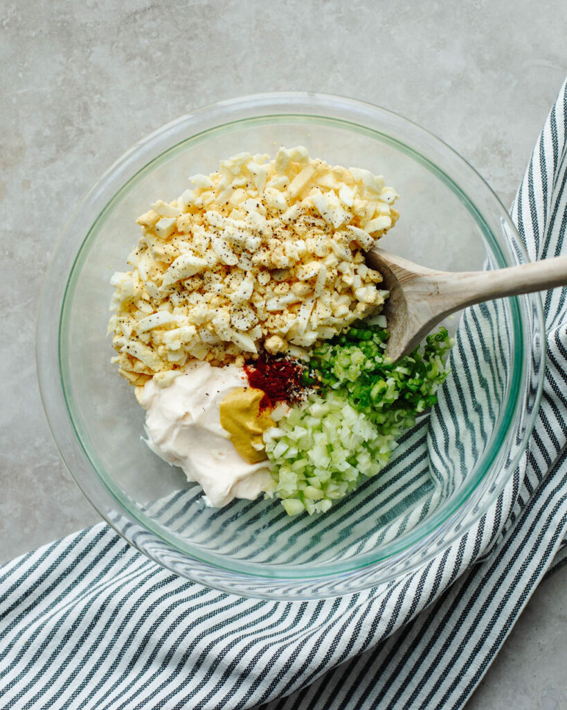 a mixing bowl of ingredients to make the best egg salad.