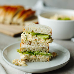 a sandwich stacked on a white plate.