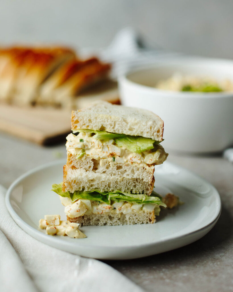a sandwich stacked on a white plate.
