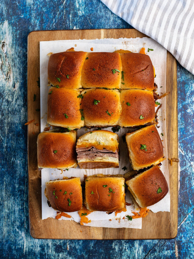 roast beef sliders baked in the oven and topped with fresh parsley.