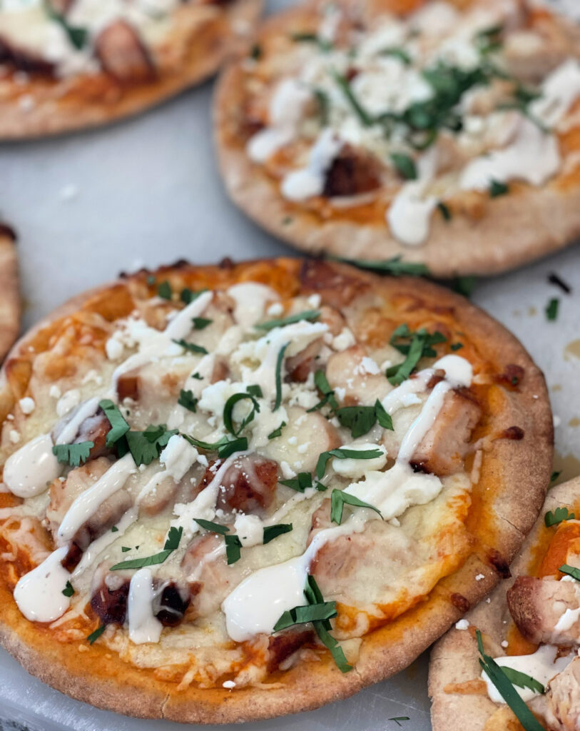 shredded chicken and buffalo sauce cooked on a flatbread to create a pizza