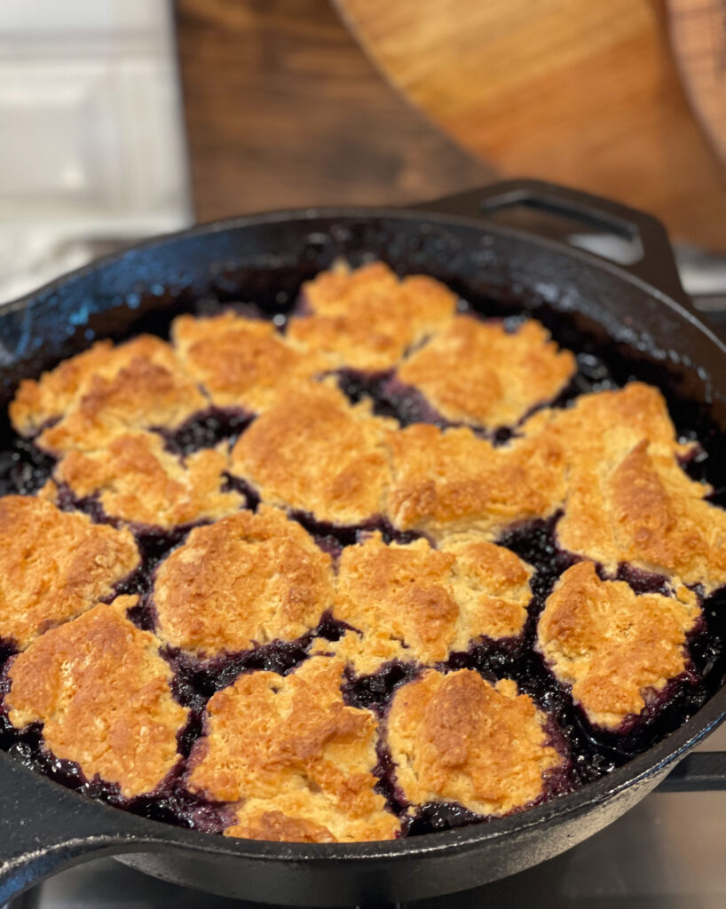 blueberry cobbler cooked in a cast iron skillet