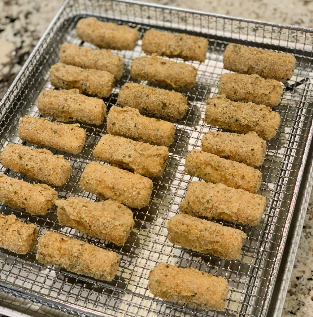 homemade mozzarella sticks lined up ready to place in the air fryer