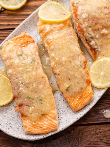 lemon garlic salmon fillets on a white serving tray.
