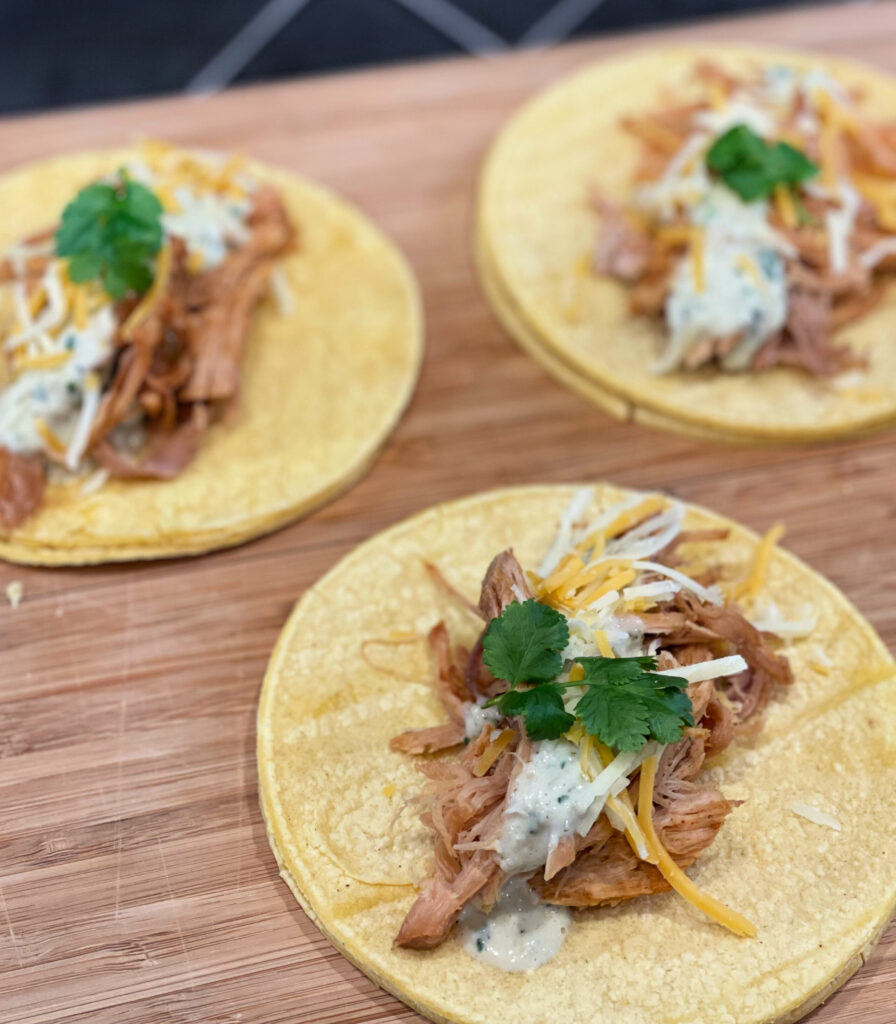 shredded pork on tortilla shells with a cilantro lime sauce for tacos