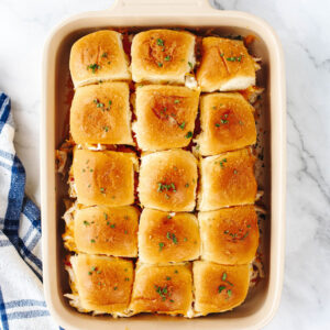 a casserole dish filled with chicken sliders ready to serve.