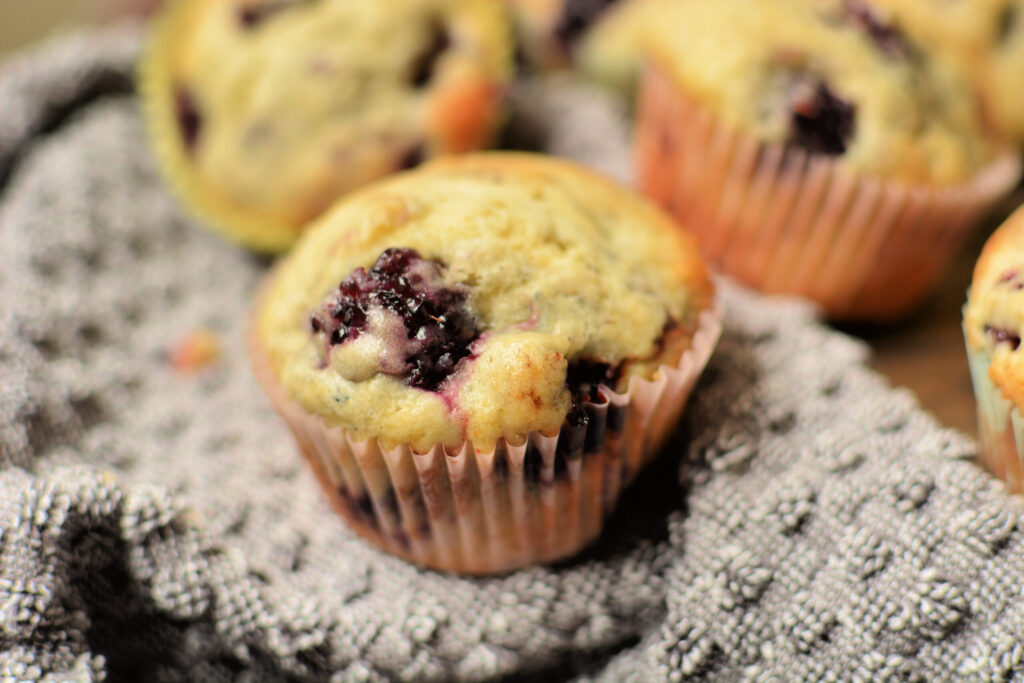 a tender and fluffy muffin with juicy blackberries throughout