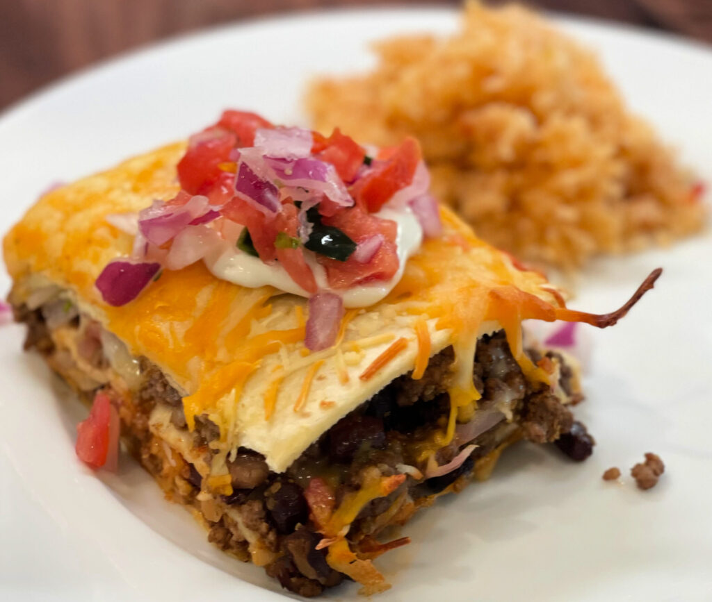 ground beef, beans, and cheese layered in tortillas to create a lasagna