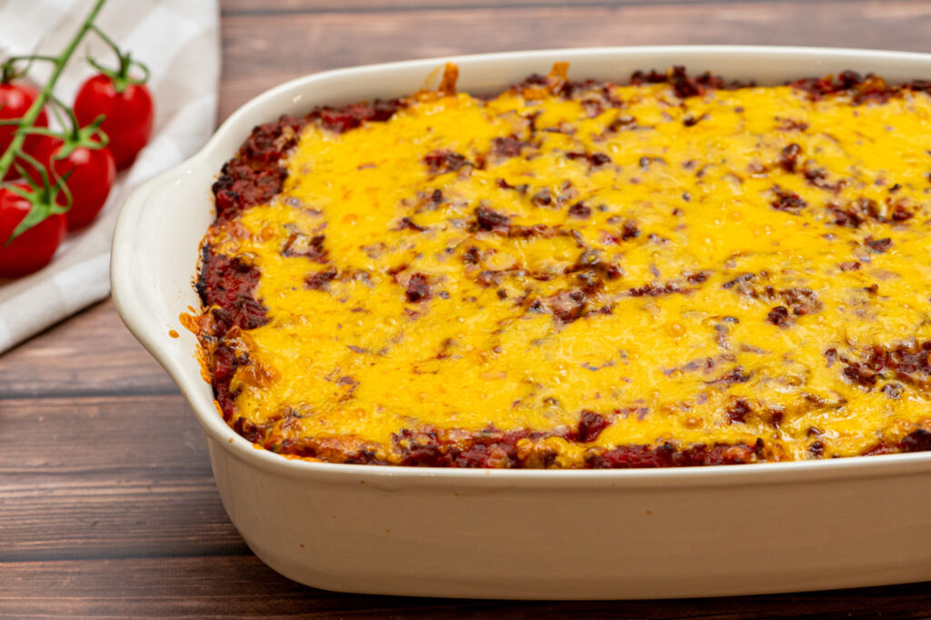 a cheesy spaghetti baked casserole with pasta, sauce, cheese, and meat.
