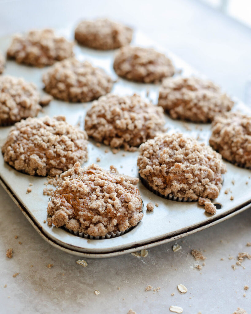 a muffin tin full of muffins with a cinnamon topping.