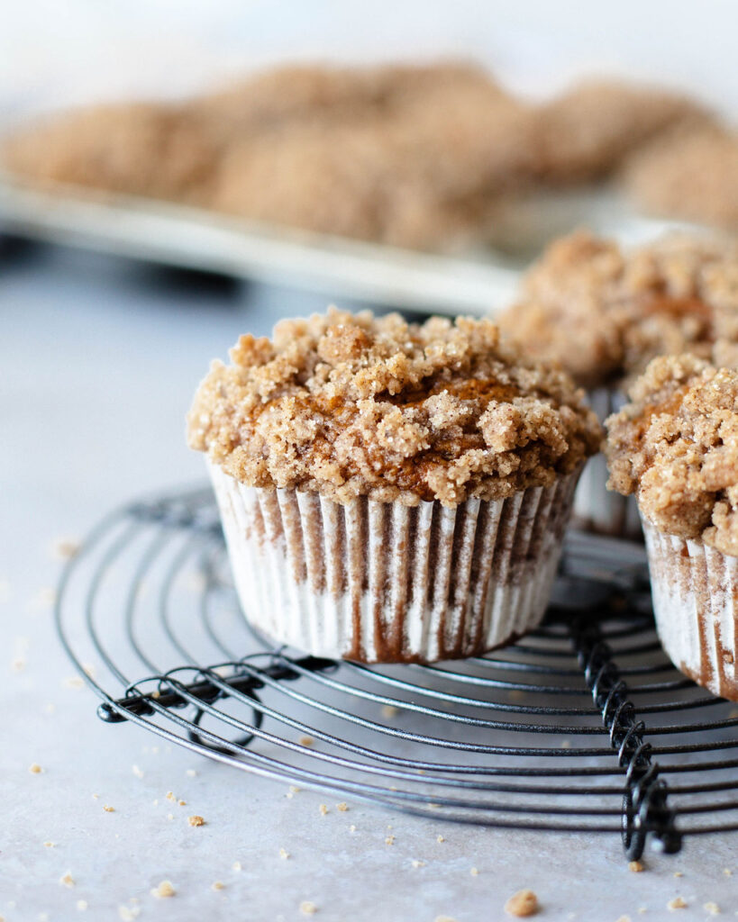 an up close look at a cinnamon streusel pumpkin muffin on a wire rack.
