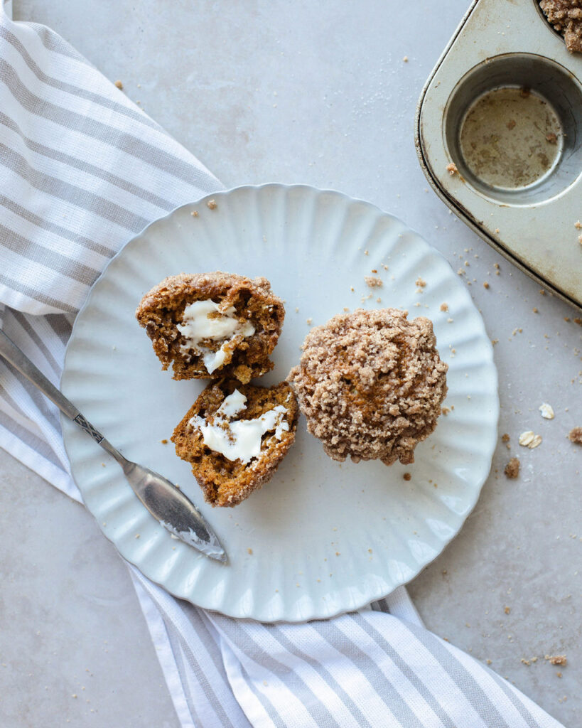 a warm spiced muffin cut in half on a white plate.