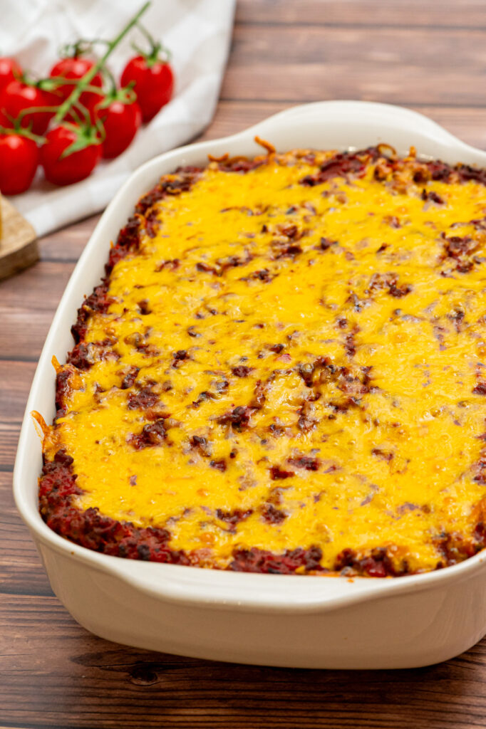 a cheesy topped spaghetti casserole with layers of meat, sauce, and pasta.