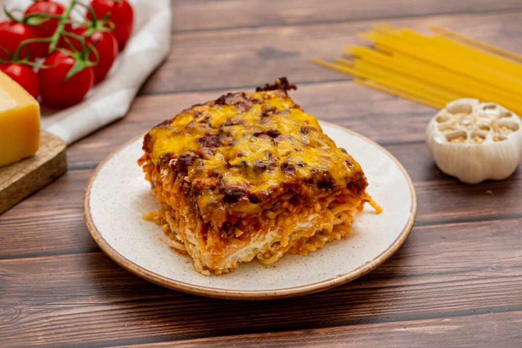 a cheesy pasta dish served on a white dinner plate.