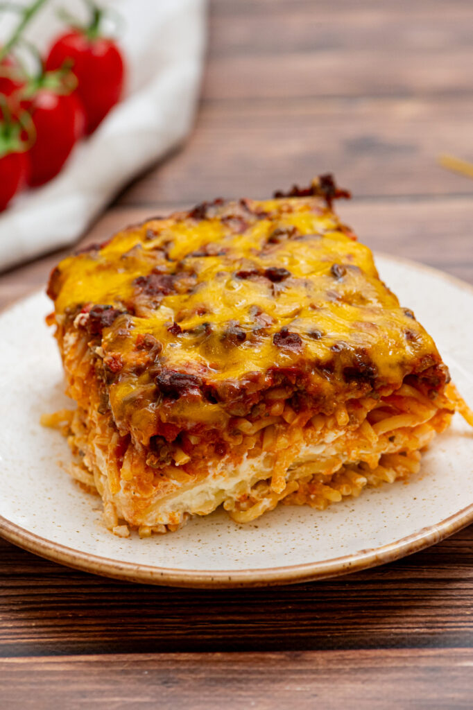 a slice of million dollar spaghetti on a white plate.