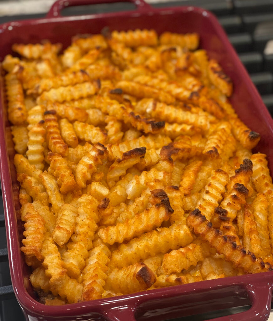 french fries and a ground beef mixture layered into a cheesy casserole