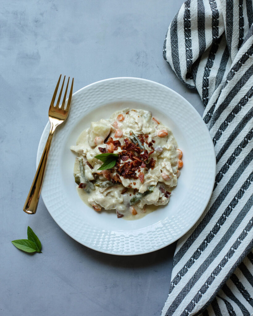 a white bowl with a hearty soup inside.