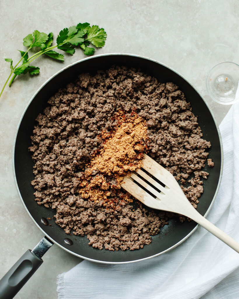 ground beef seasoned with taco seasoning in a skillet.
