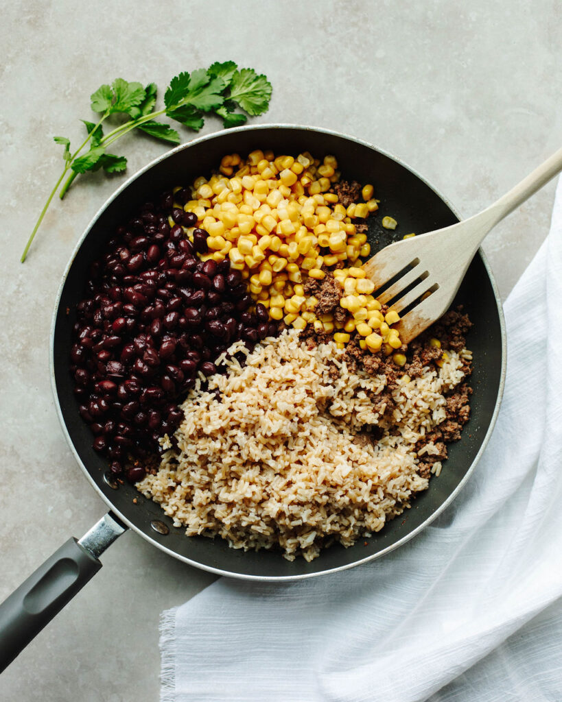 black beans, beef, corn, and rice in a skillet for stuffing in Taco Stuffed Peppers.