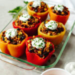 sour cream on top of bell peppers that have a ground beef mixture inside.