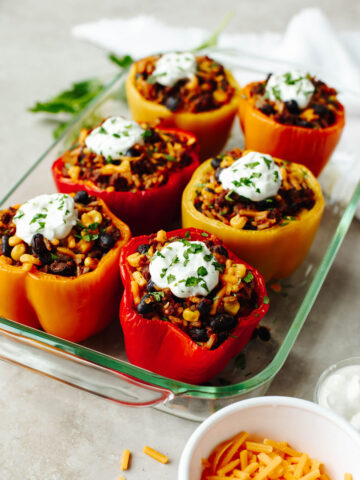 sour cream on top of bell peppers that have a ground beef mixture inside.