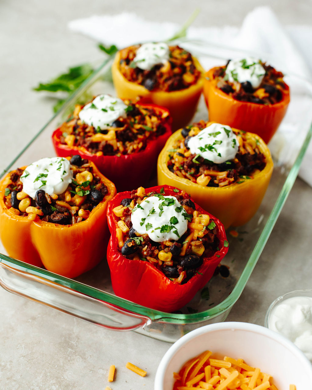 sour cream on top of bell peppers that have a ground beef mixture inside.