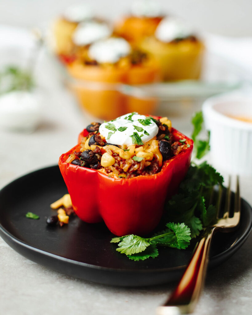 a red bell pepper stuffed and served on a black plate.