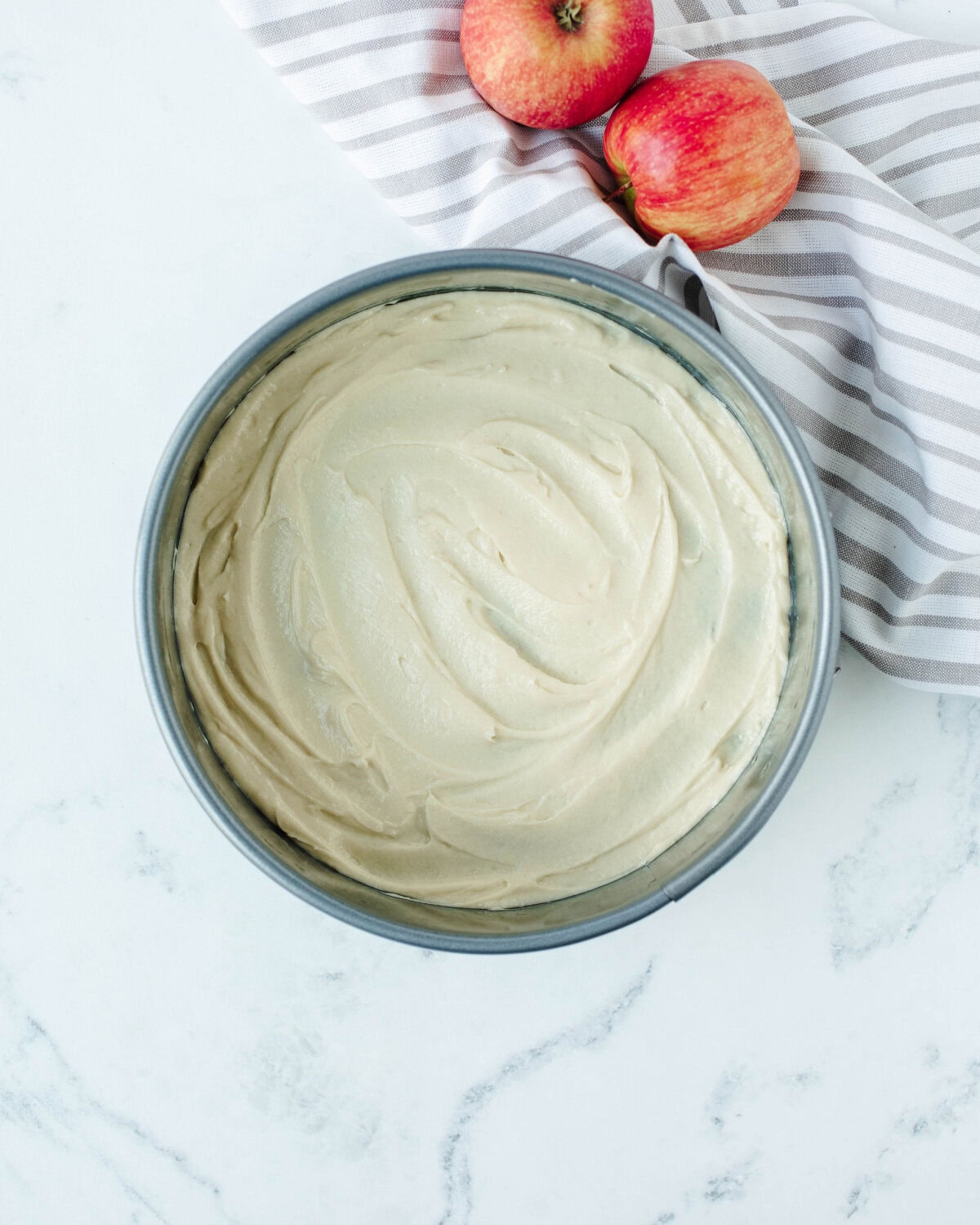 apple cake batter spread onto prepared springform pan.