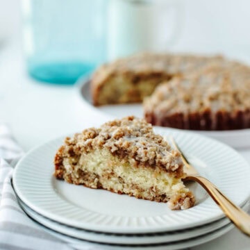 a slice of apple cinnamon crumb cake on a white plate.