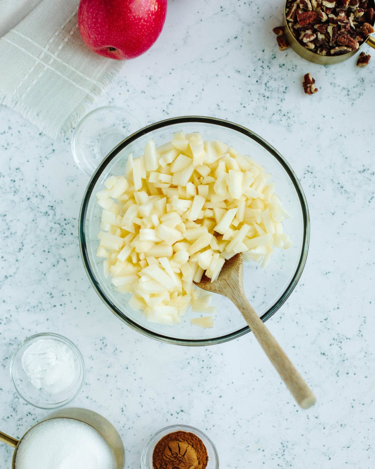 diced apples tossed with lemon juice in a glass bowl.