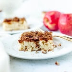 a slice of apple cream cheese cake on a white plate.