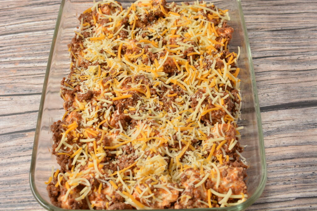 shredded cheese over seasoned ground beef and biscuit pieces