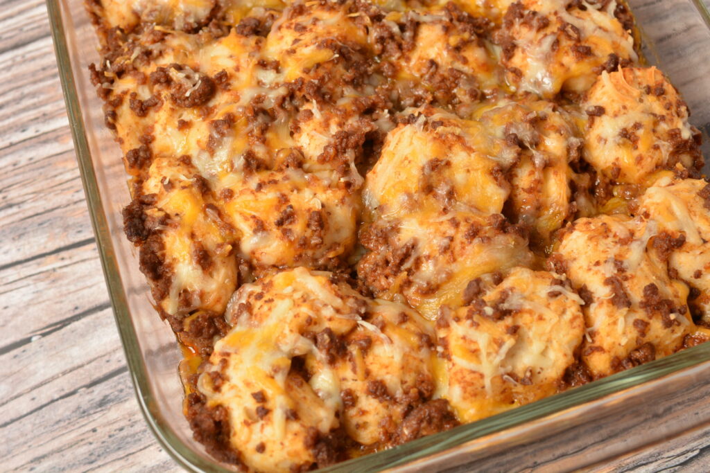 biscuits, ground beef, ketchup and seasoning covered with cheese in a casserole