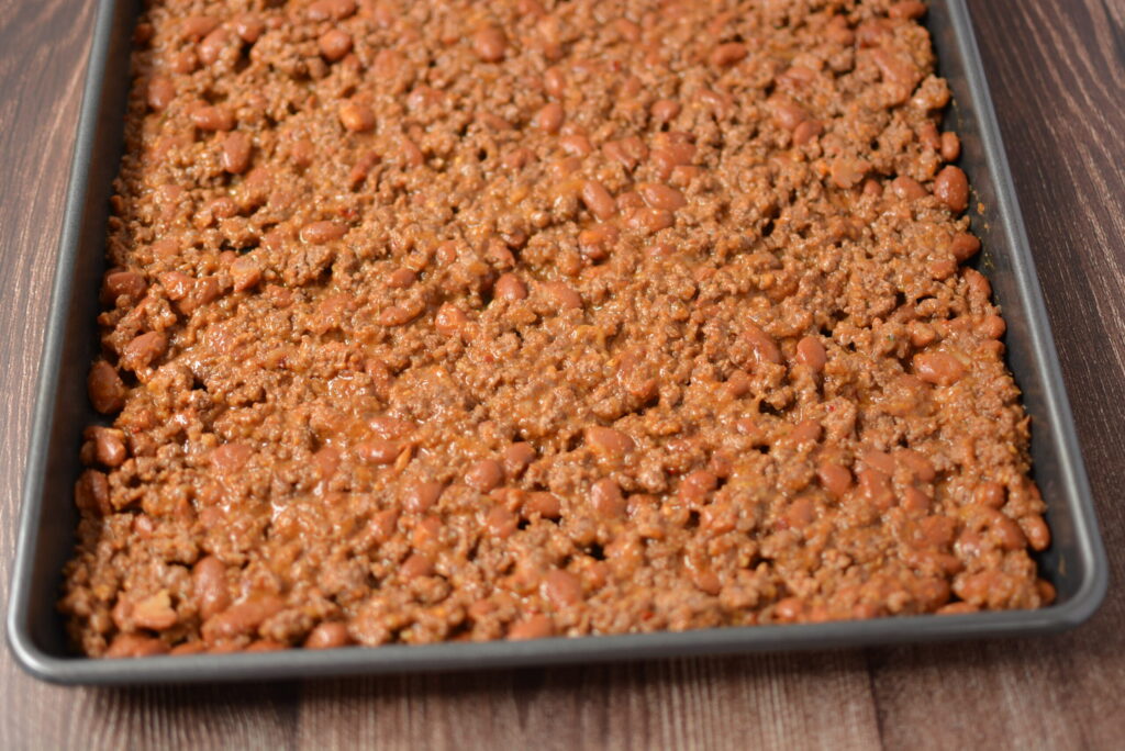 taco seasoned ground beef spread in a cookie sheet