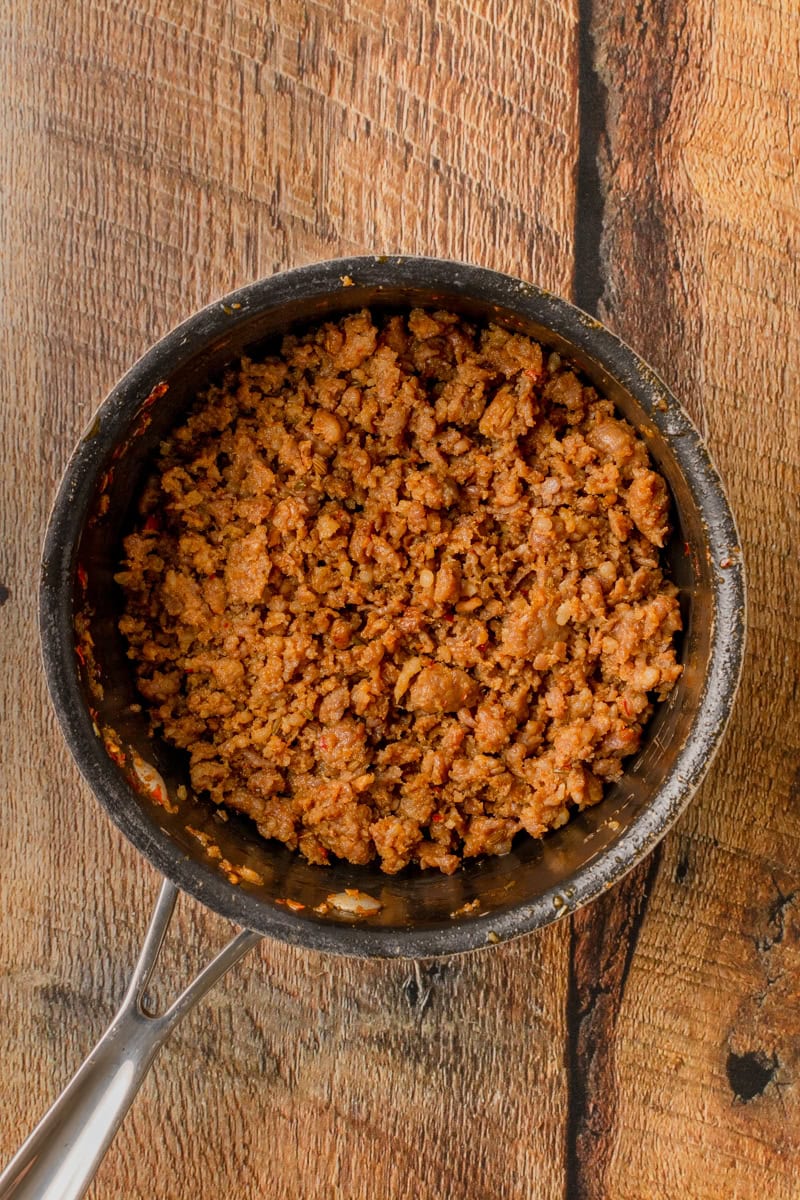 cooking Italian sausage in a pot until cooked through.