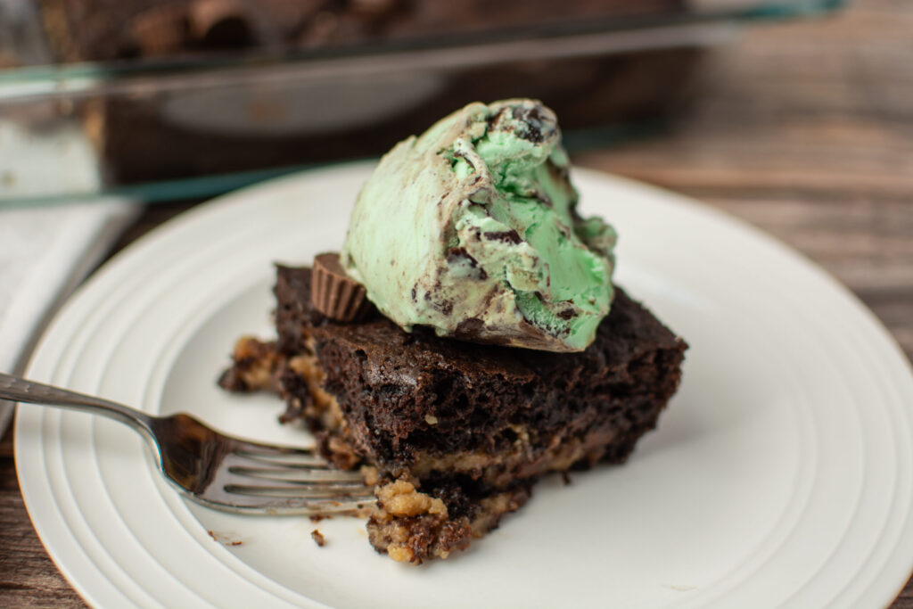 a piece of cake on a white plate with a scoop of ice cream on top.