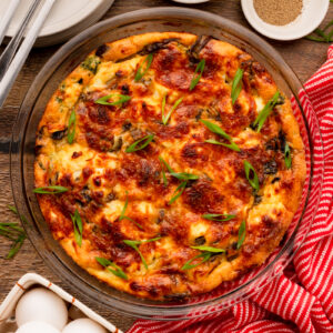 a crustless spinach mushroom feta quiche in a pie plate.