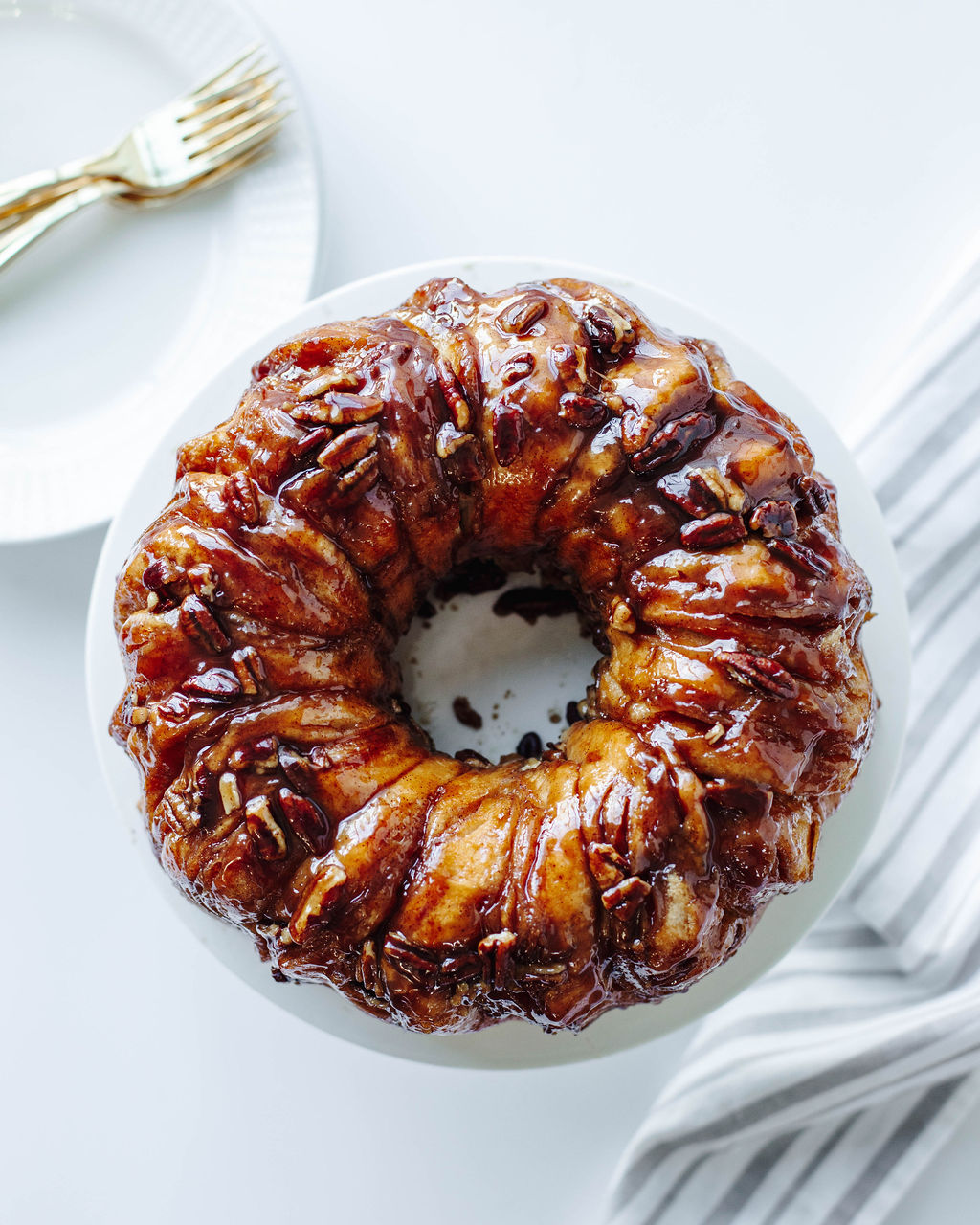 sticky bun cinnamon ring on a white plate.