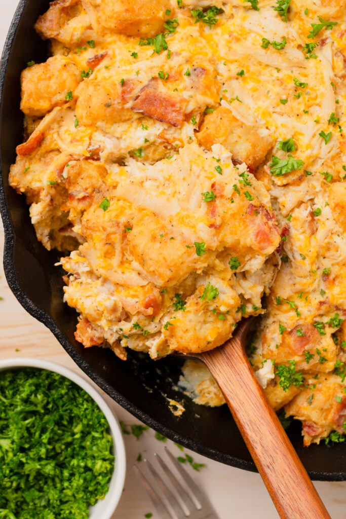 a wood spoon scooping out a one pan meal.