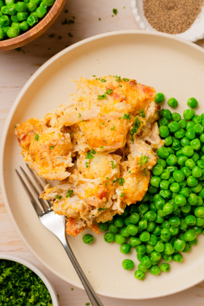 Chicken Tater Tot Casserole on a plate with peas.