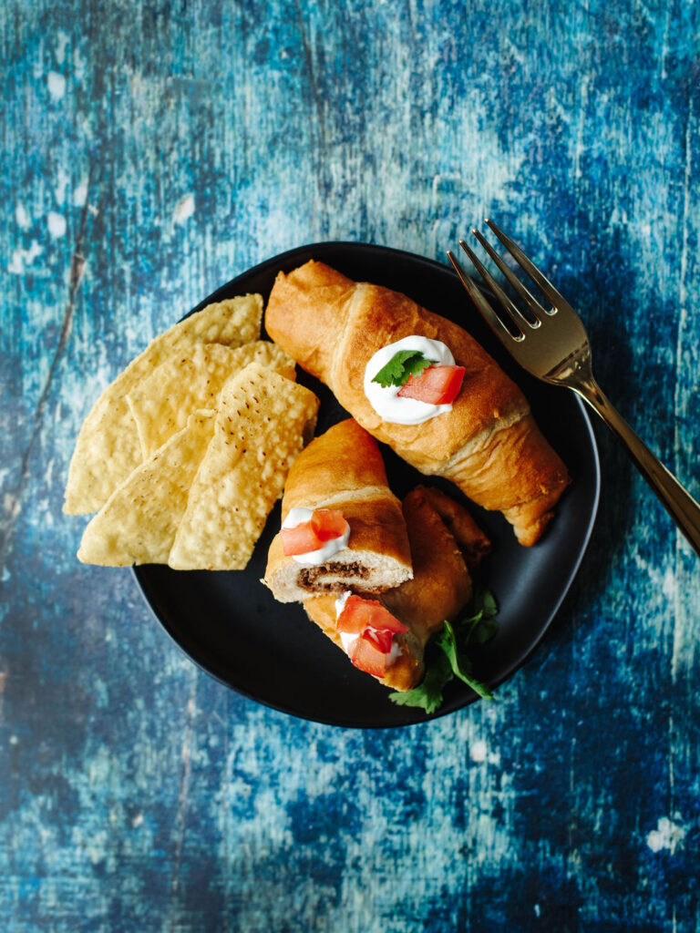 a Tex Mex inspired crescent roll taco dish served on a black plate.