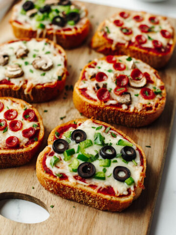 Garlic Bread Pizza on a wood cutting board.